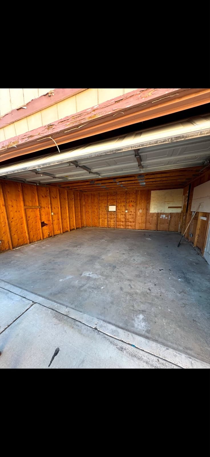 The same wood-paneled garage fully emptied and swept clean after JunkMD LV junk removal