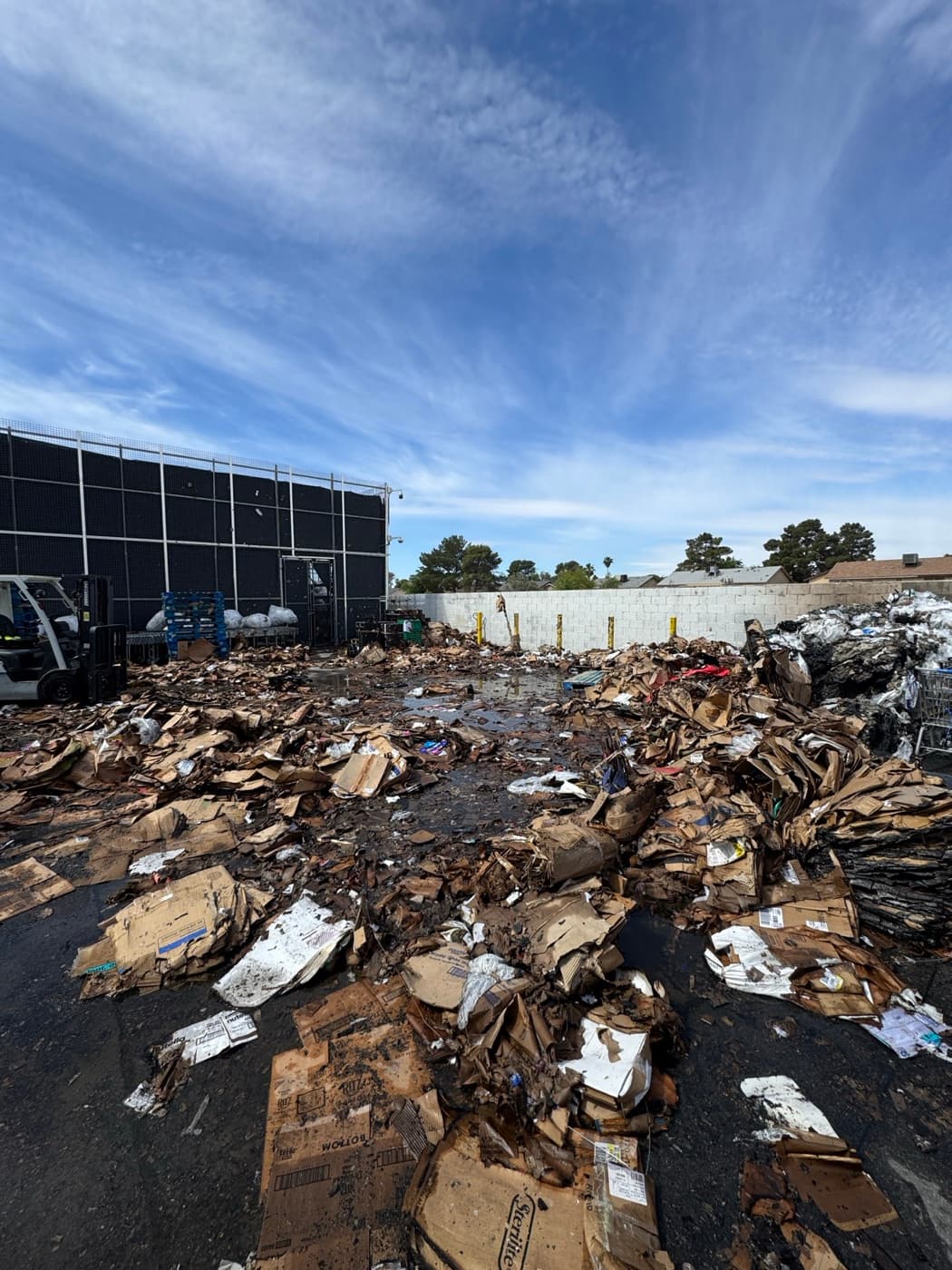 Commercial lot covered in flattened cardboard and debris before JunkMD LV cleanup